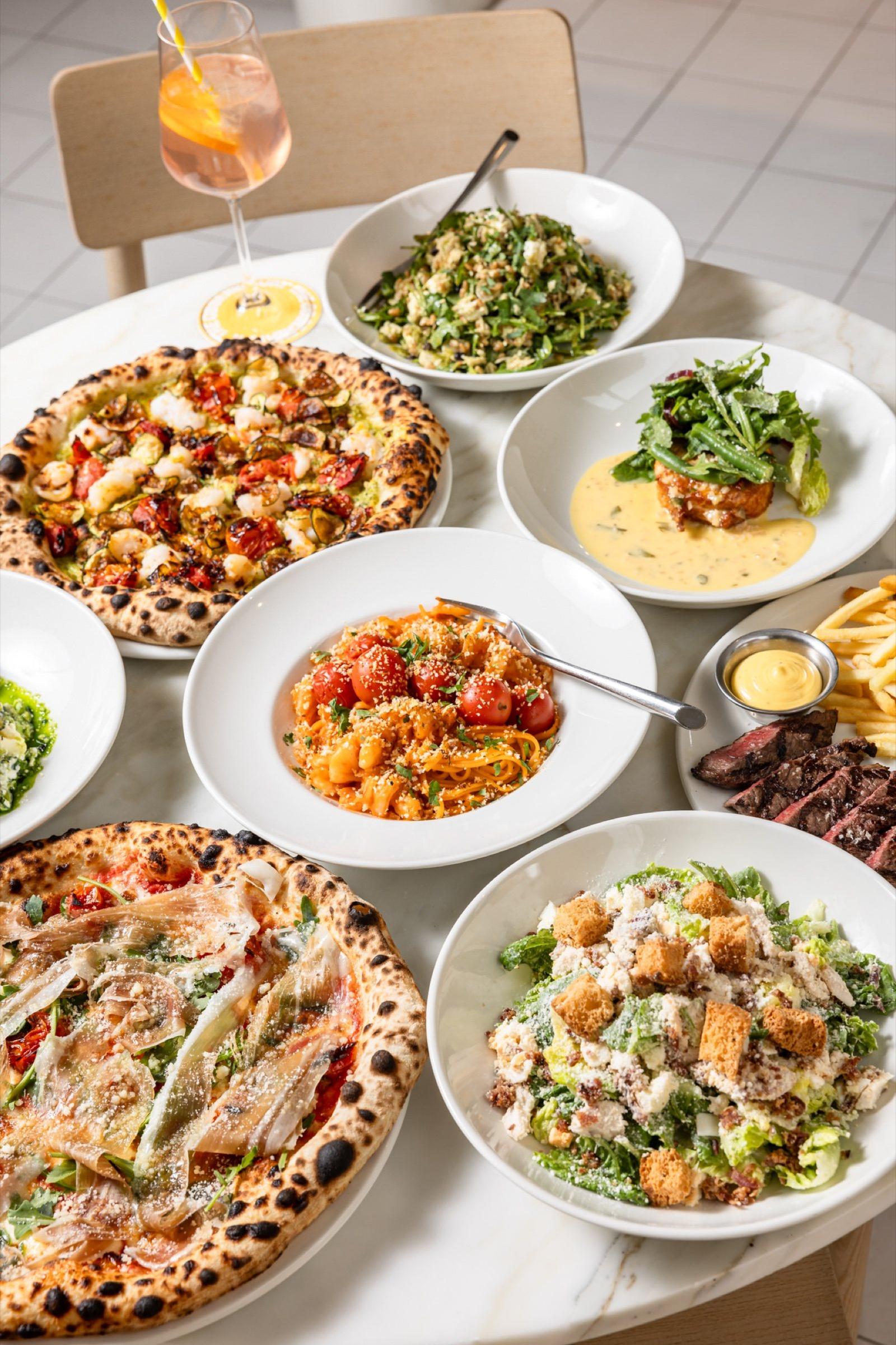 A table of pizza, pasta, salads and steak at The Observatory
