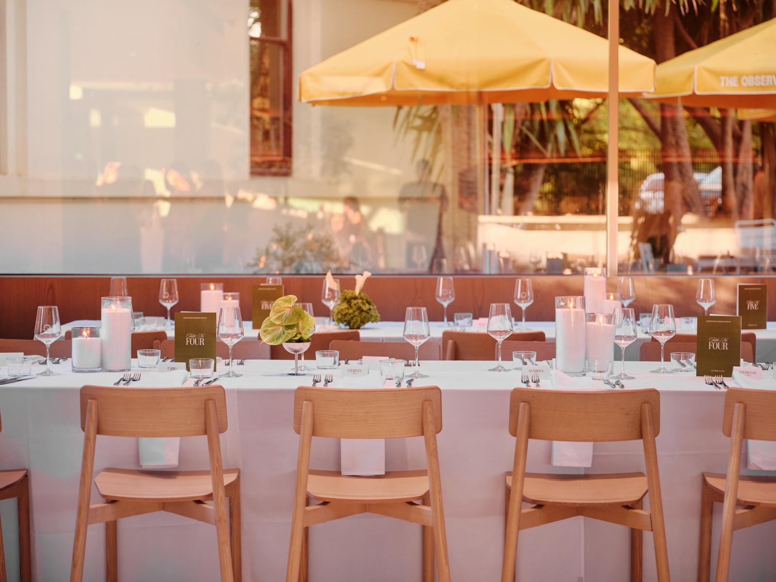 Candlelit long table in front of the courtyard umbrellas