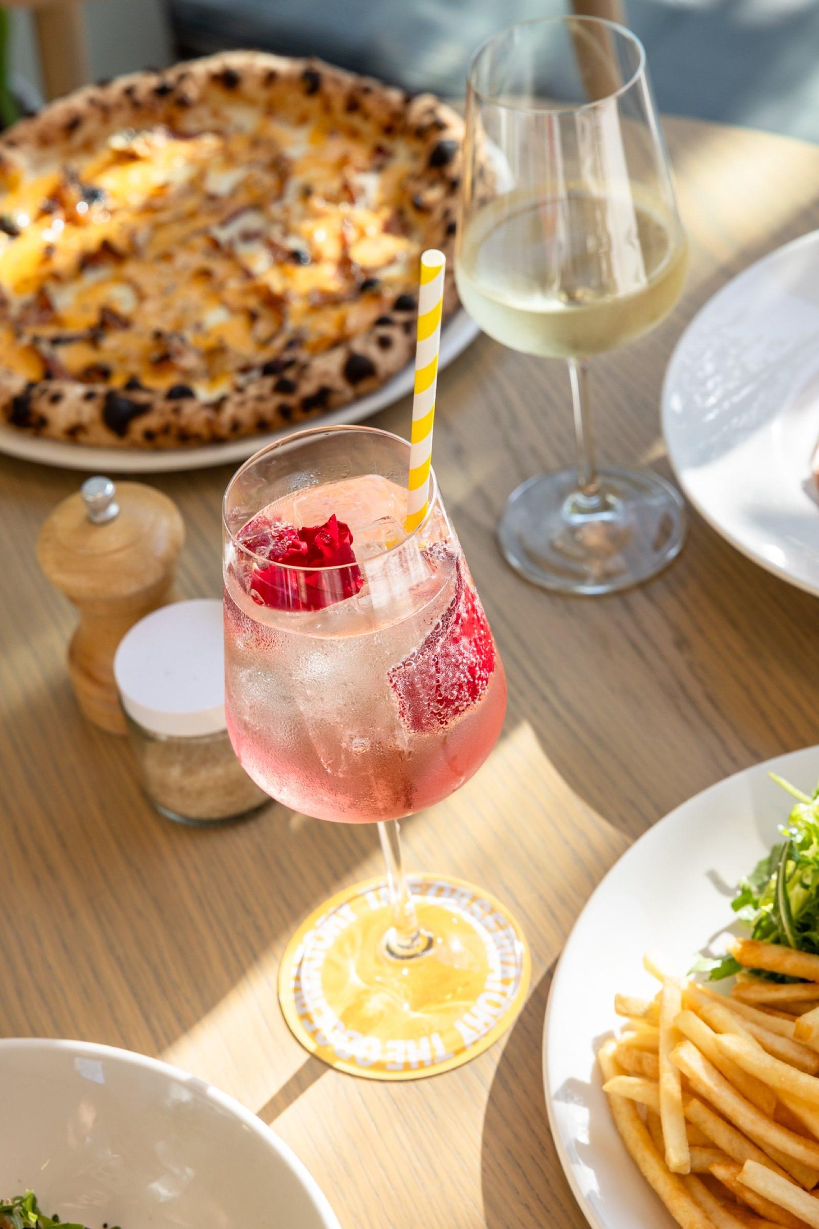 Spritz, pizza and fries on a sunny table at The Observatory